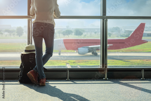 Wallpaper Mural woman passenger of the airplane keep standing by in waiting hall for boarding the aircraft for arrival/departure, looking live incoming and outgoing airplane in the hall Torontodigital.ca