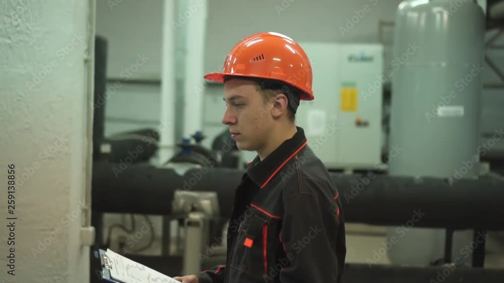 a young engineer is in a technical room. at the factory a young engineer is in a technical room. at the factory