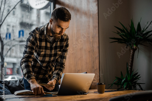 Concentration on a process. Side view of smart male copywriter concentrated on remote job preparing publication for web page sitting at netbook.Designer watching webinar to improve skills on laptop 