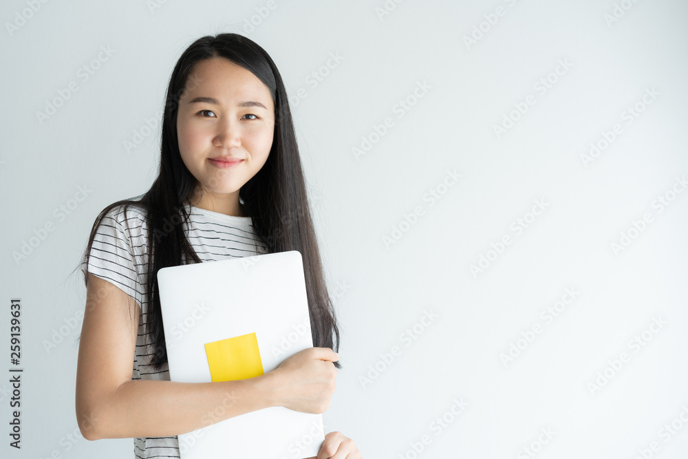 Asian woman is holding laptop on white background . Portrait a young girl so cute when smiling and happy. Asian woman is holding laptop on white background . Portrait a young girl so cute when smiling and happy.