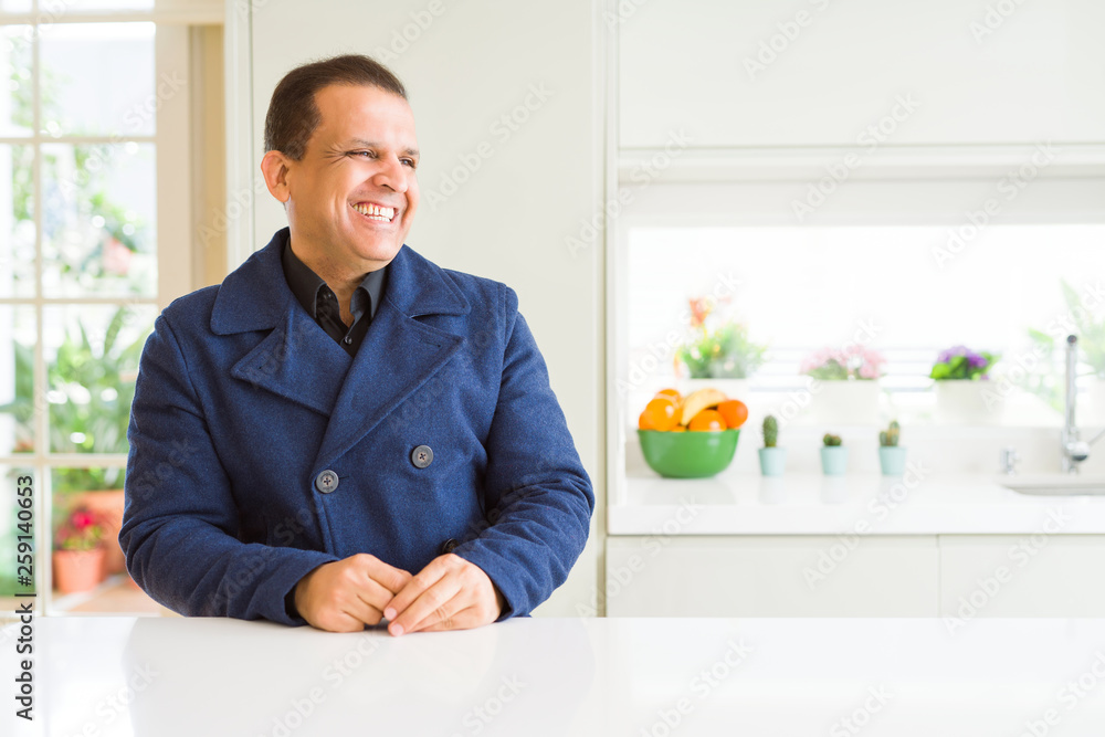 Middle age man sitting at home looking away to side with smile on face, natural expression. Laughing confident. Middle age man sitting at home looking away to side with smile on face, natural expression. Laughing confident.