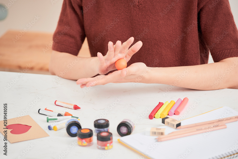 Female hands working with polymer clay. The process of working with the plastic on a white background. Female hands working with polymer clay. The process of working with the plastic on a white background.