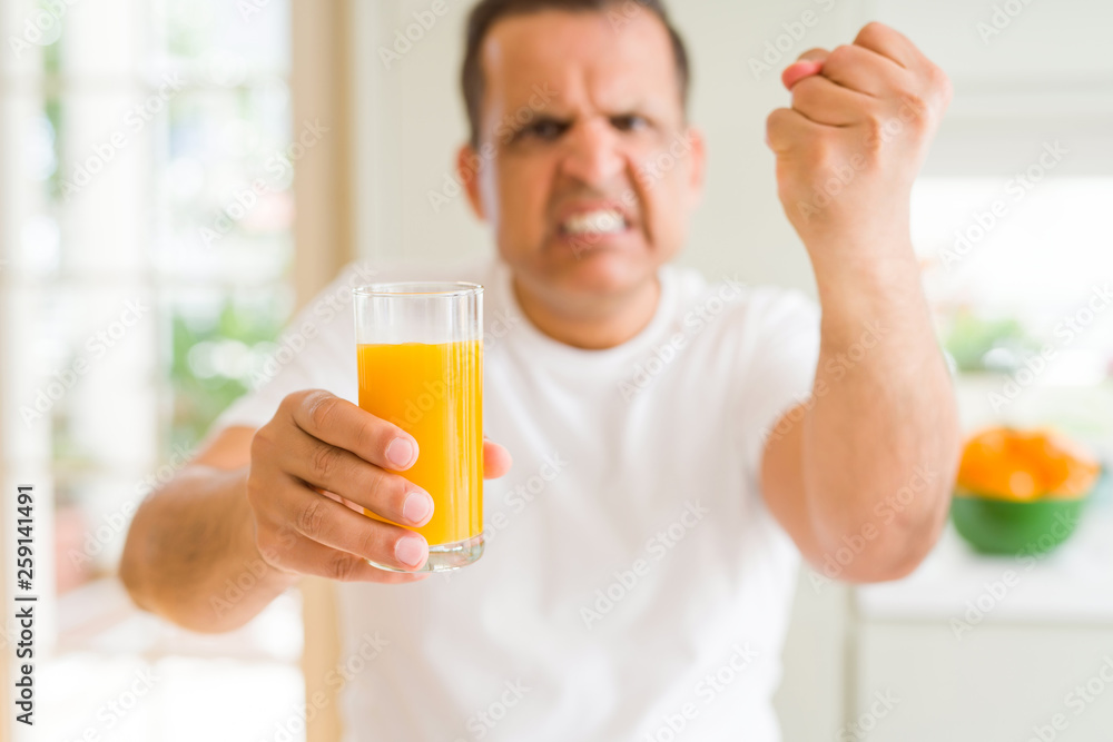 Middle age man drinking a glass of orange juice at home annoyed and frustrated shouting with anger, crazy and yelling with raised hand, anger concept Middle age man drinking a glass of orange juice at home annoyed and frustrated shouting with anger, crazy and yelling with raised hand, anger concept