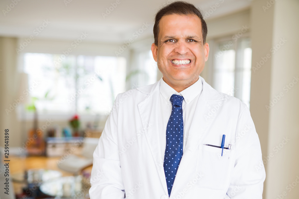 Middle age man wearing white medical coat and smiling Middle age man wearing white medical coat and smiling
