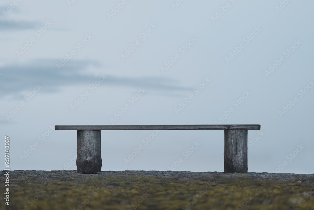 Empty homemade wooden bench on a hill.