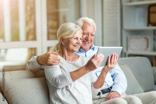 Senior couple using digital tablet at home