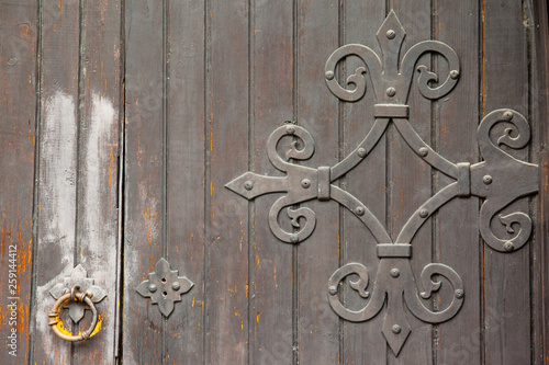 antique wooden door with wrought hinges and door knocker