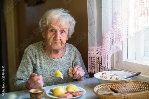 Elderly woman portrait dines in his home.