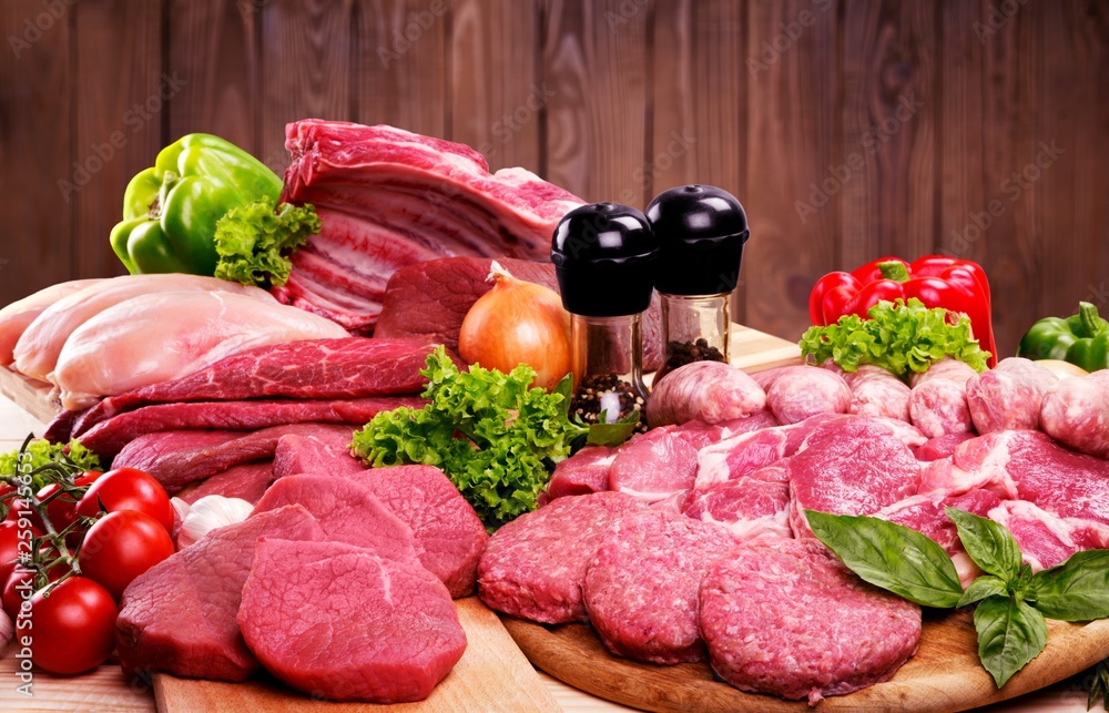 Fresh raw meat background with vegetables on wooden desk isolated on white background Fresh raw meat background with vegetables on wooden desk isolated on white background