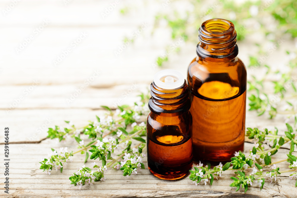 thyme essential oil and thyme flowers on the wooden board thyme essential oil and thyme flowers on the wooden board