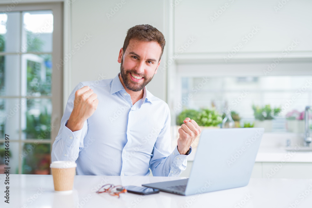 Handsome man working using computer laptop and drinking a cup of coffee screaming proud and celebrating victory and success very excited, cheering emotion