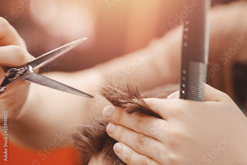 Vintage toning, master barber makes hair to man hipster