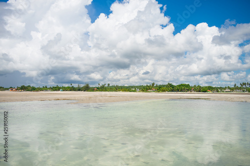 Cloudy sky reflecting on shallow waters at Sossego beach on Itamaraca island, Brazil