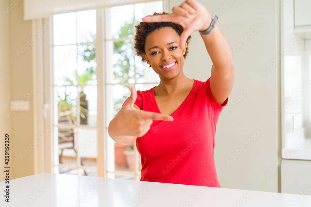 Young beautiful african american woman at home smiling making frame with hands and fingers with happy face. Creativity and photography concept. Young beautiful african american woman at home smiling making frame with hands and fingers with happy face. Creativity and photography concept.