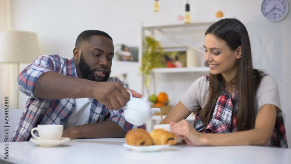 Young multiethnic couple drinking tea, black man caring about girlfriend, love Young multiethnic couple drinking tea, black man caring about girlfriend, love