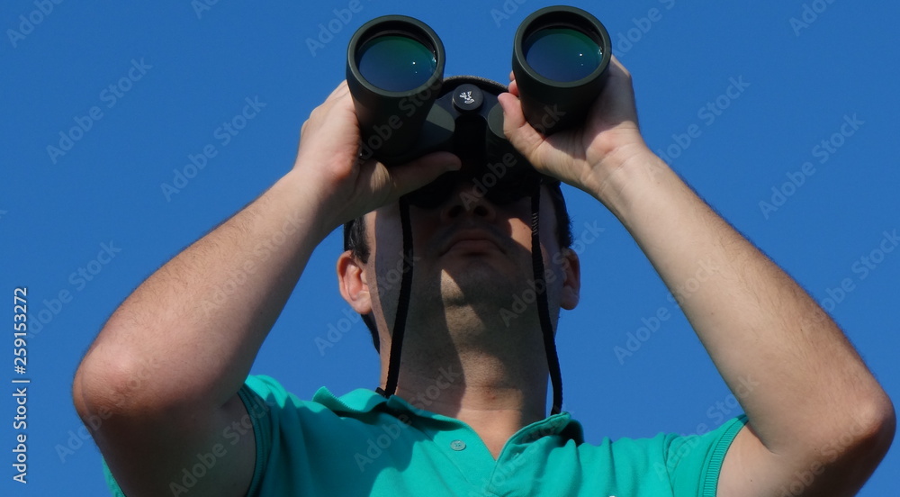 man looking through binoculars man looking through binoculars