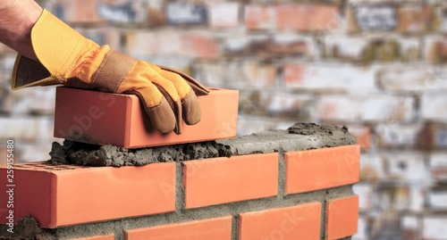 Worker builds a brick wall in the photo