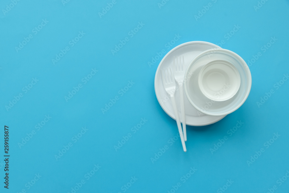 Fototapeta premium Disposable white plastic plates and forks on blue background. Copy space. Top view. Eco, plastic free and save earth concept.