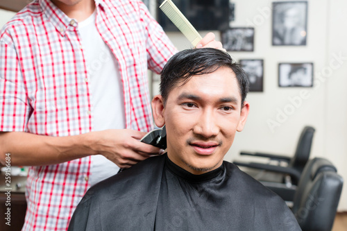 Barber cutting man's hair