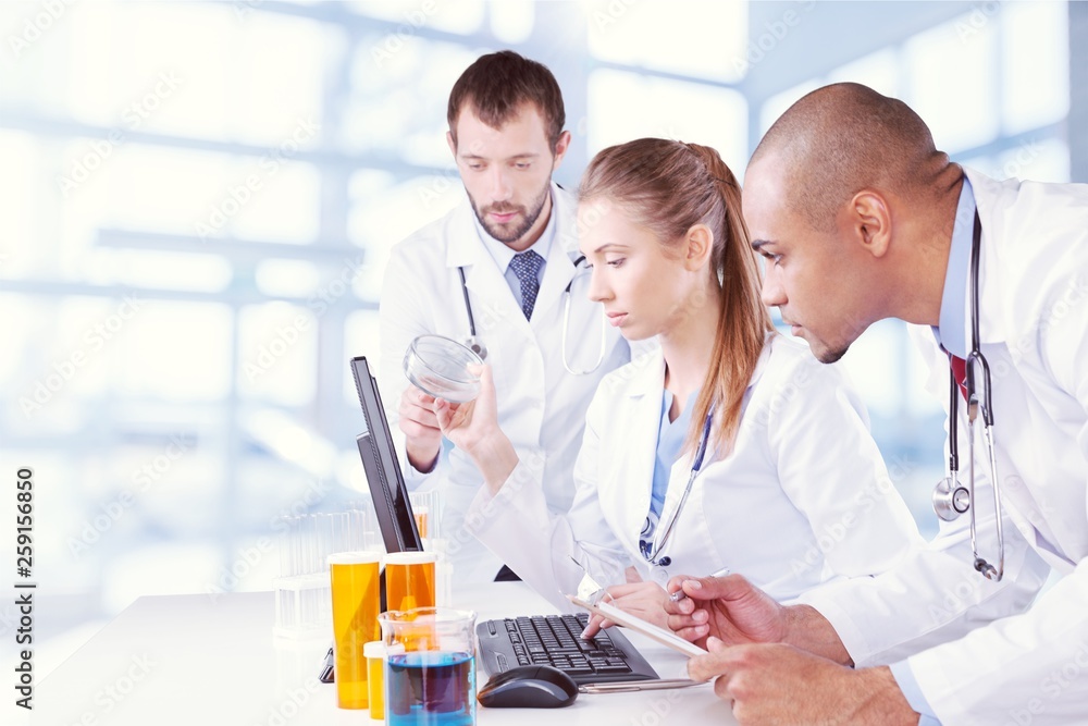 Female and male scientists in glasses working with microscope Female and male scientists in glasses working with microscope