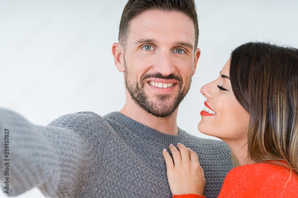 Beautiful young couple in love, kissing and hugging each other taking a selfie picture Stock