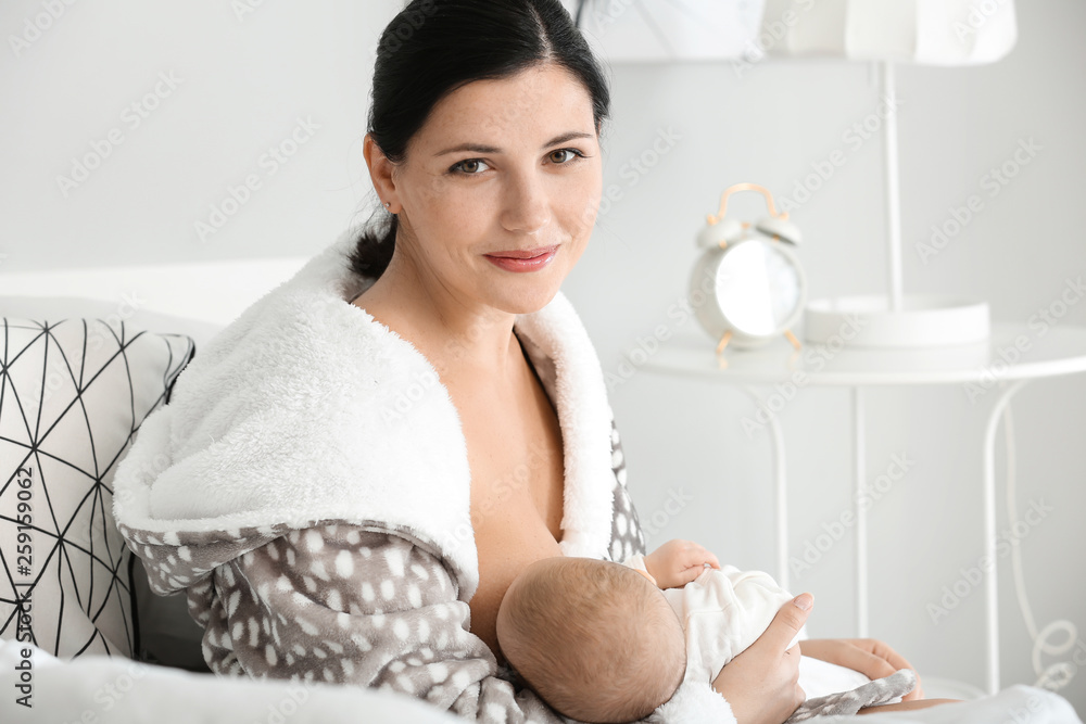 Young woman breastfeeding her baby at home Young woman breastfeeding her baby at home
