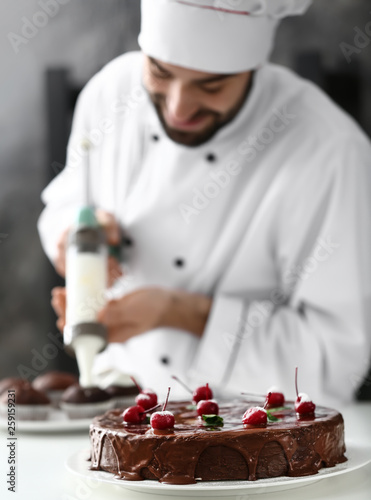 Tasty cake on table of confectioner in kitchen photo