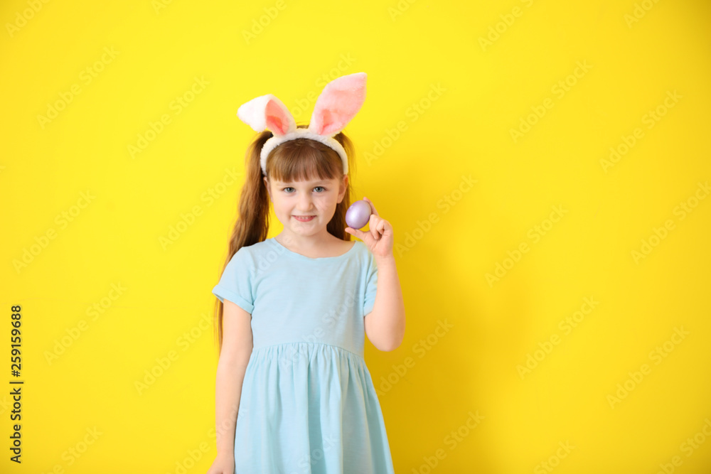 Cute little girl with Easter egg and bunny ears on color background Cute little girl with Easter egg and bunny ears on color background