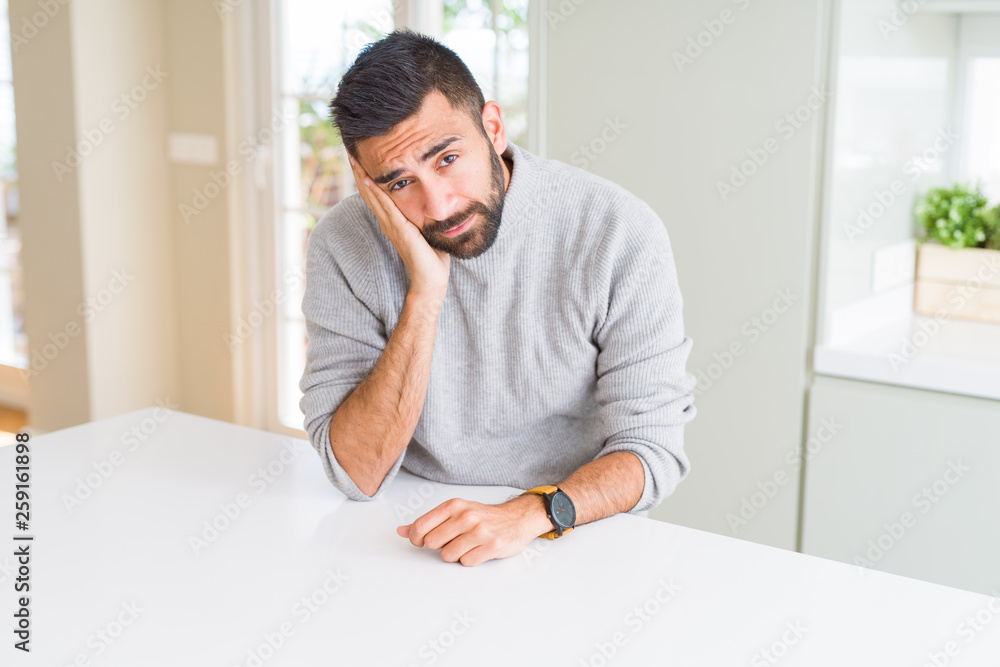 Handsome hispanic man wearing casual sweater at home thinking looking tired and bored with depression problems with crossed arms. Handsome hispanic man wearing casual sweater at home thinking looking tired and bored with depression problems with crossed arms.