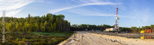 a panorama of a drilling rig on a sand dumping in the forest in the morning