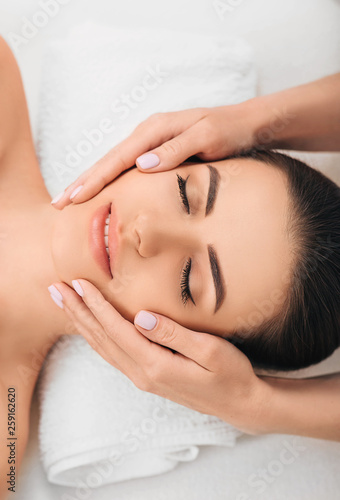 young woman getting a head massage at a spa. Face massage with perfect clean and fresh skin