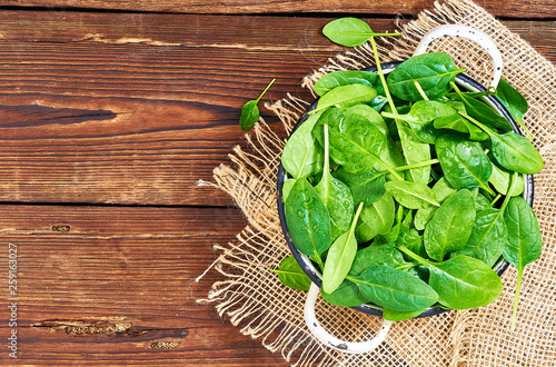 Fresh spinach leaves in a wooden background