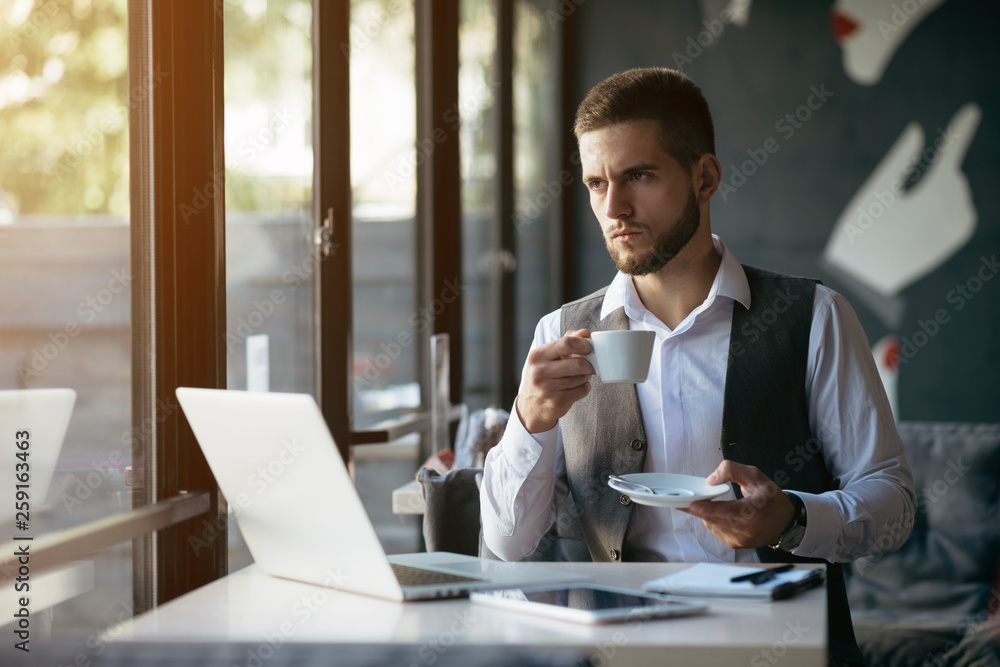 Young man drawing template for the web site associated with digital marketing, current trends and tendencies of UX / UI design. Businessman who rules his company remotely, like a freelancer Young man drawing template for the web site associated with digital marketing, current trends and tendencies of UX / UI design. Businessman who rules his company remotely, like a freelancer
