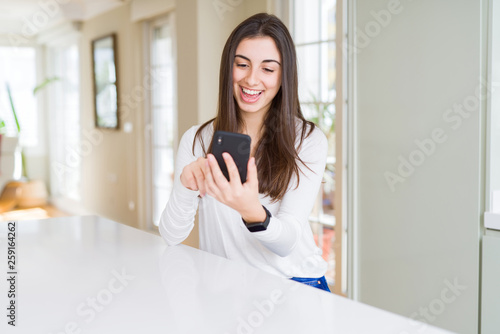 Free Download Young woman using smartphone, smiling happy texting and typing - GFXLoad