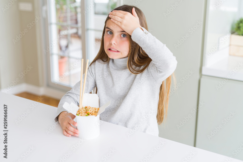 Beautiful young girl kid eating asian rice in delivery box stressed with hand on head, shocked with shame and surprise face, angry and frustrated. Fear and upset for mistake. Beautiful young girl kid eating asian rice in delivery box stressed with hand on head, shocked with shame and surprise face, angry and frustrated. Fear and upset for mistake.