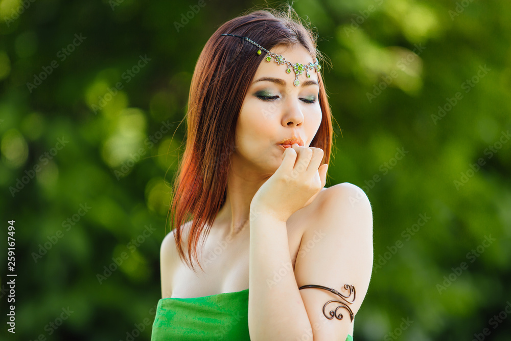 Beautiful young asian woman eating fresh kiwi, holding thumb close to the lips Beautiful young asian woman eating fresh kiwi, holding thumb close to the lips