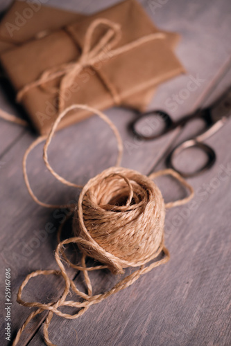 Roll of rustic rope with gift packages in the background