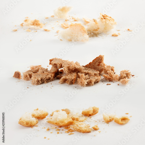Scattered bread crumbs on white background, top view