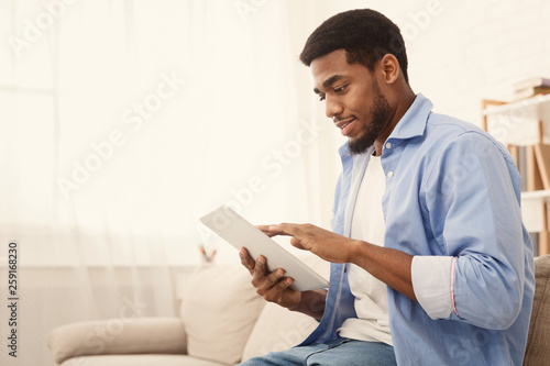 Young african american man using digital tablet