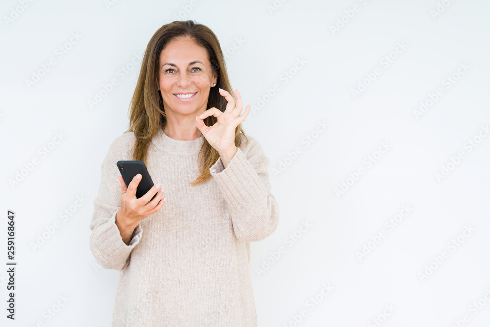 Middle age woman using smartphone over isolated background doing ok sign with fingers, excellent symbol Middle age woman using smartphone over isolated background doing ok sign with fingers, excellent symbol