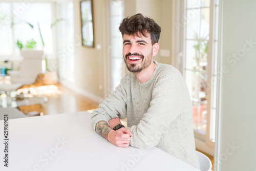 Handsome young man smiling cheerful at the camera with crossed arms and a big smile on face showing teeth © Krakenimages.com