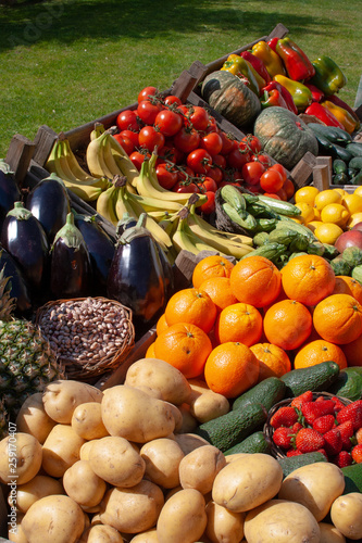 Beautiful composition of various fresh and ripe biological vegetables and fruits in wooden boxes in a market