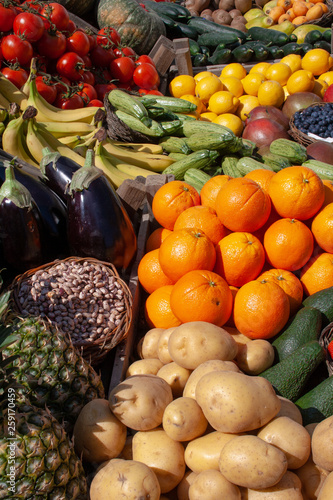 Beautiful composition of various fresh and ripe biological vegetables and fruits in wooden boxes in a market