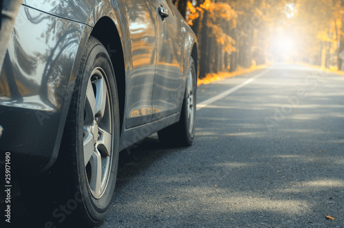 closeup car tires wheel vehicle on asphalt road in autumn forest leaves fall driving trip transportation to travel in nature woods holidays travel safety adventure countryside vacation relaxing.