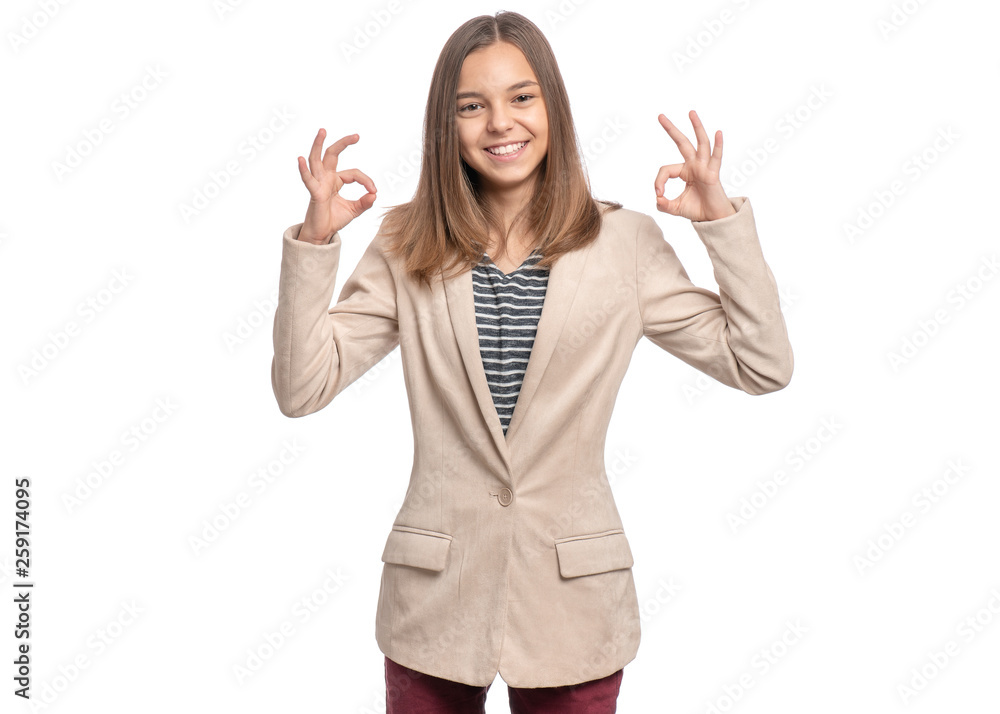 Beautiful Teen Girl Student in suit making Ok Gesture. Portrait of caucasian Smiling Teenager isolated on white background. Happy child looking at camera. Beautiful Teen Girl Student in suit making Ok Gesture. Portrait of caucasian Smiling Teenager isolated on white background. Happy child looking at camera.