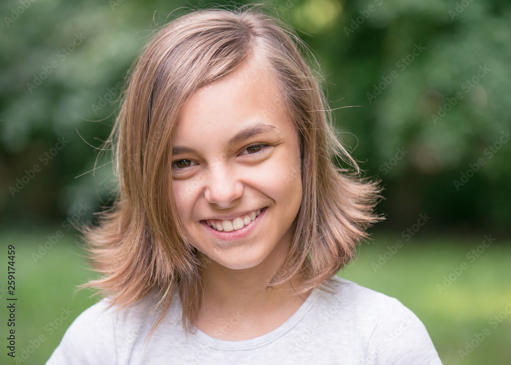 Portrait of attractive caucasian little student girl with beautiful brown eyes. Happy smiling child looking at camera - close-up, outdoors. Portrait of attractive caucasian little student girl with beautiful brown eyes. Happy smiling child looking at camera - close-up, outdoors.