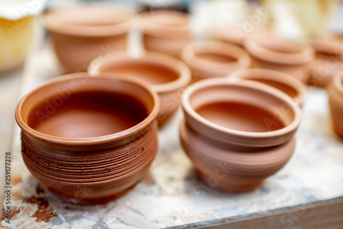 Close-up of clay pitchers before baking on the shelves at the pottery