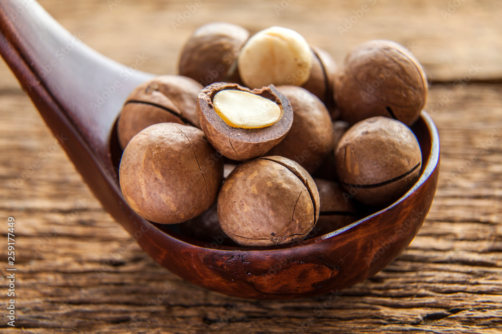 Close up macadamia nuts on wooden plate Close up macadamia nuts on wooden plate
