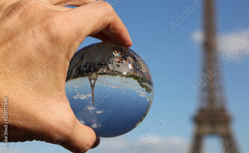 Crystal Sphere on the hand and the Eiffel Tower in Paris