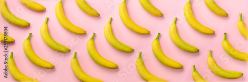 Geometric colorful fruit pattern. Bananas over pink background. Banner. Top v...